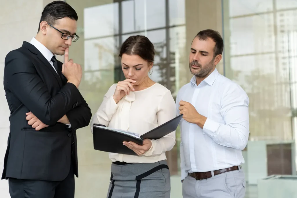 Een directeur en twee medewerkers van een bedrijf zijn op zoek naar een bedrijf voor Hoogspanningscabine Plaatsen.